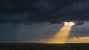 A storm front over open country with one break in the cloud letting light reach the ground, for the study on why bad things happen